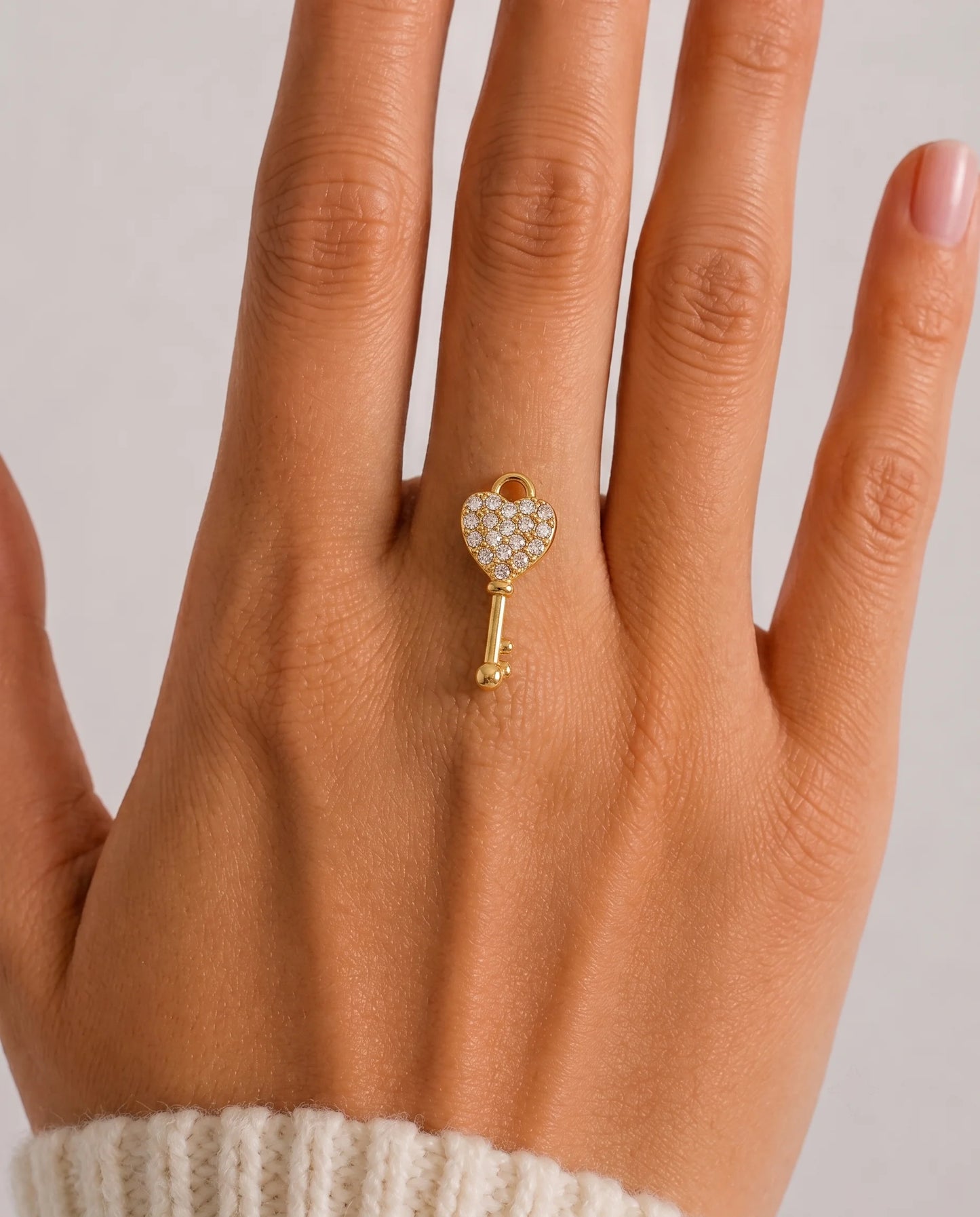 Zierlicher, goldener Anhänger aus 18K vergoldetem Titanstahl in Form eines Schlüssels mit einem herzförmigen, mit Zirkonia-Kristallen besetzten Kopf für personalisierbare Armbänder und Ketten
