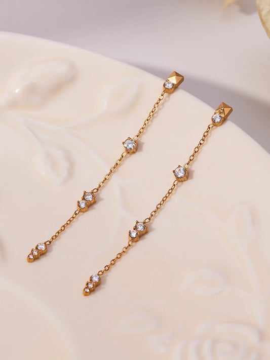 Filigrane Aria's Starlight Drop Ohrringe aus 18K vergoldetem Titanstahl mit hängenden Zirkonia-Steinen auf weißem Hintergrund