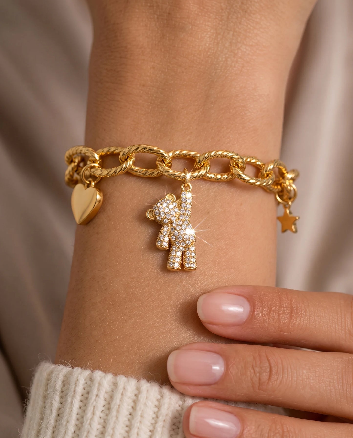 Goldener Anhänger aus 18K vergoldetem Titanstahl in Form eines kleinen Bären, der an einem Arm hängt und großzügig mit klaren Zirkonia-Kristallen besetzt ist, für personalisierbare Armbänder und Ketten