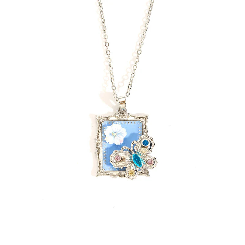 Silberne Halskette "Clara" aus Edelstahl mit rechteckigem Bilderrahmen-Anhänger, blauer Emaille und buntem Kristall-Schmetterling
