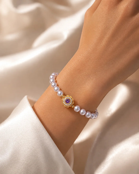 Lia's Lavendel-Blüte Armband aus zartvioletten Kunstperlen mit einem blumenförmigen goldenen Anhänger und violettem Zirkonia