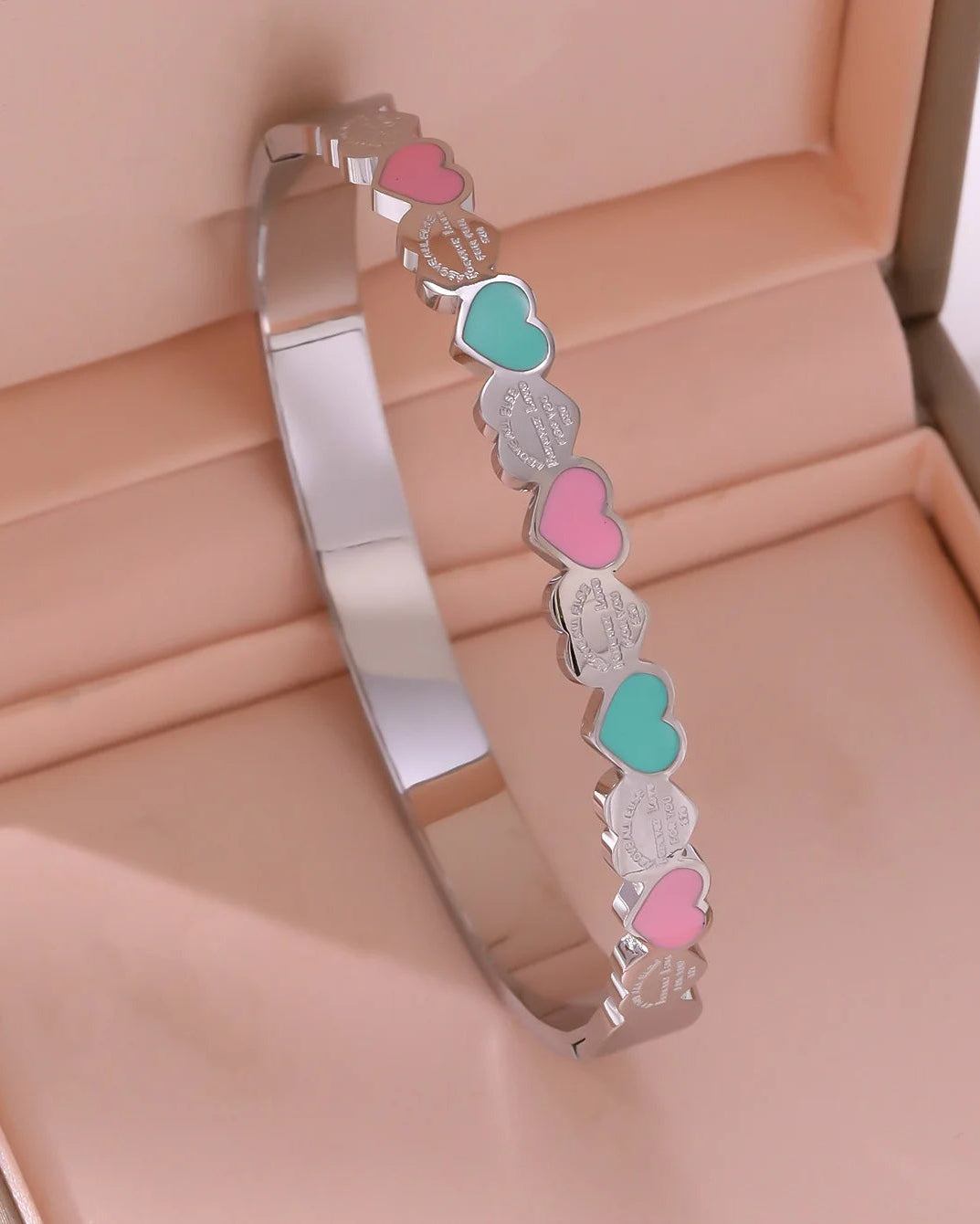 Silver-tone Lottie bangle with pink and green hearts in a jewellery box
