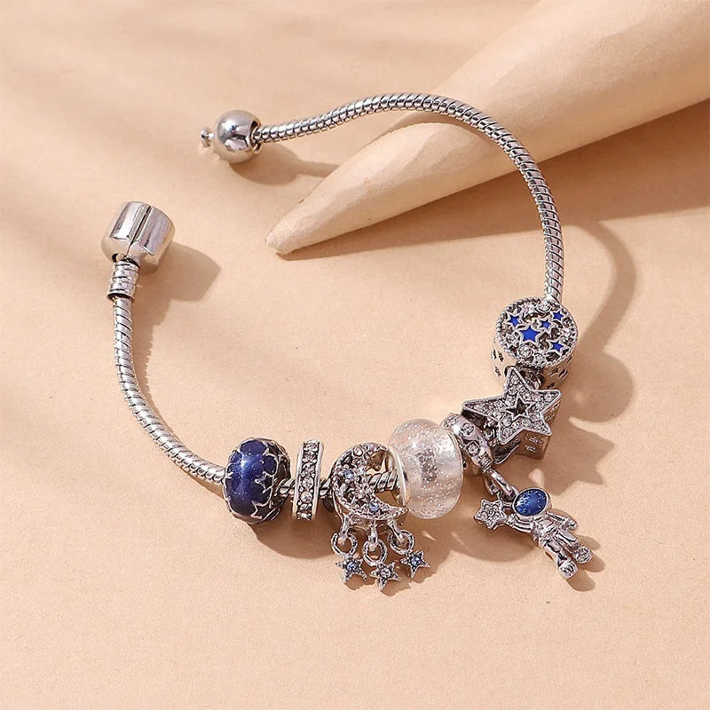 Silbernes Edelstahl-Armband "Lyra" mit blauen Galaxie-Perlen und Anhängern von Astronaut, Mond und Sternen