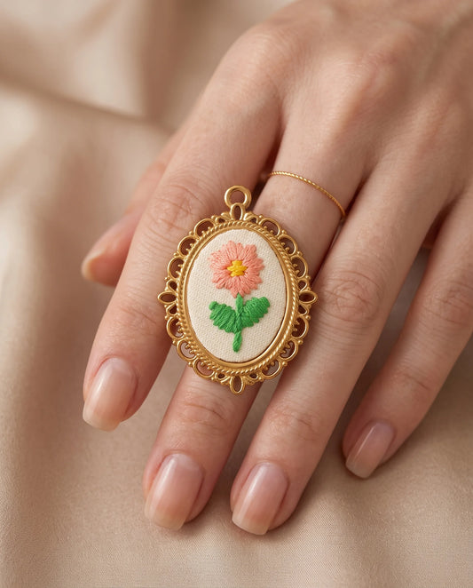 Matilda Stickerei Charm aus vergoldetem Titanstahl im Detail