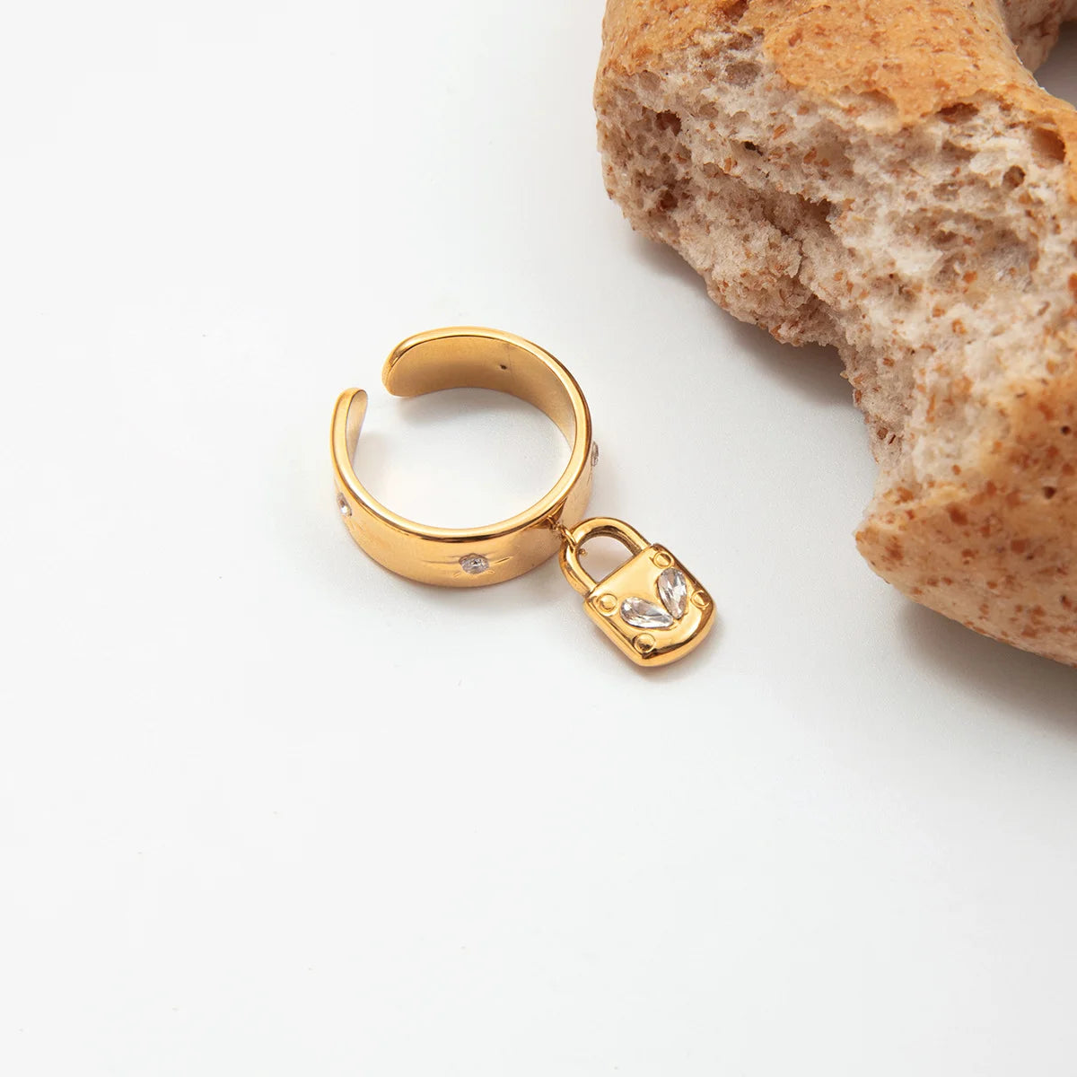 Goldener, breiter Edelstahl-Ring "Nora" mit Stern-Gravuren und einem hängenden Herz-Schloss-Charm