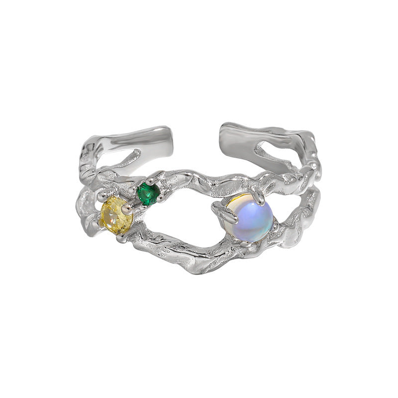 Offener Damenring aus 925er Silber mit leuchtendem Mondstein und bunten Zirkonia, präsentiert auf AURAGLEAM-Karte – elegantes, kunstvolles Design