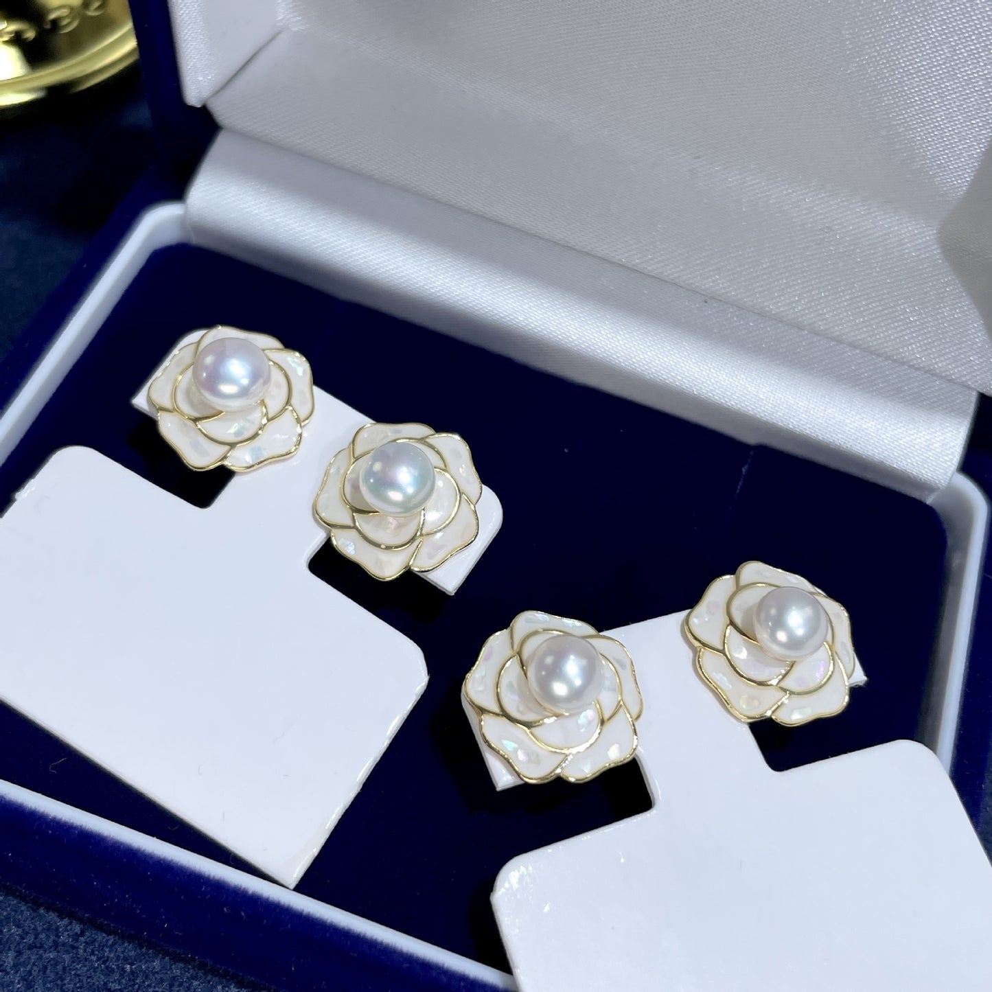Elegante Ohrstecker in Kamelienform mit schimmernder Süßwasserperle und zartem Perlmutt – gefertigt aus 925er Silber, ideal für romantische Looks