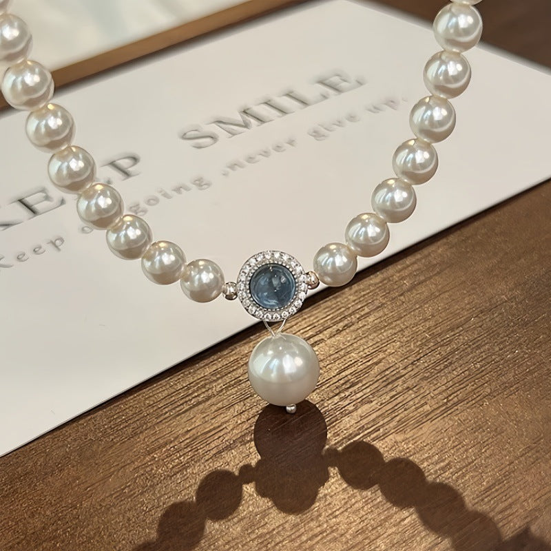 Nahaufnahme einer eleganten Damen-Halskette aus S925 Silber mit schimmernden Swarovski Kristallperlen und rundem Aquamarin-Anhänger – luxuriöser Perlenschmuck für besondere Anlässe