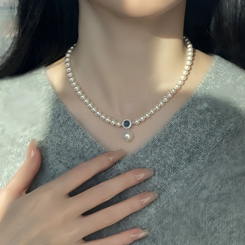 Nahaufnahme einer eleganten Damen-Halskette aus S925 Silber mit schimmernden Swarovski Kristallperlen und rundem Aquamarin-Anhänger – luxuriöser Perlenschmuck für besondere Anlässe
