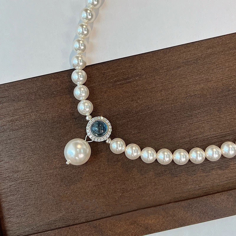 Nahaufnahme einer eleganten Damen-Halskette aus S925 Silber mit schimmernden Swarovski Kristallperlen und rundem Aquamarin-Anhänger – luxuriöser Perlenschmuck für besondere Anlässe