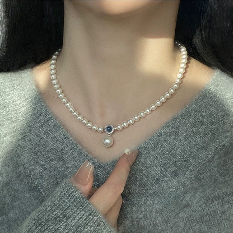 Nahaufnahme einer eleganten Damen-Halskette aus S925 Silber mit schimmernden Swarovski Kristallperlen und rundem Aquamarin-Anhänger – luxuriöser Perlenschmuck für besondere Anlässe