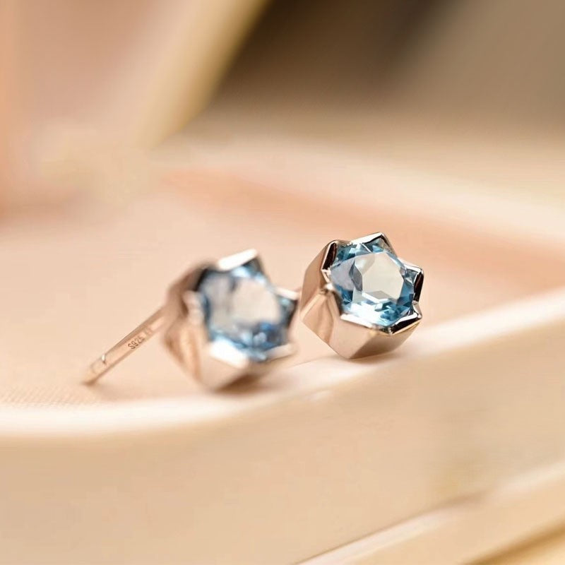 Elegante Ohrstecker aus 925er Silber mit facettiertem Blautopas im funkelnden Sternschliff – himmelblauer Blickfang für jeden Anlass