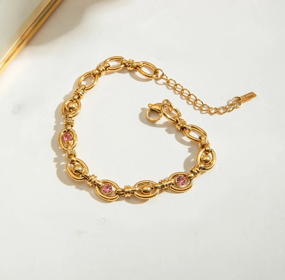 Goldenes Titanstahl-Armband "Sophie" mit ovalen Gliedern, besetzt mit rosa Zirkonia und goldenen Kugeln