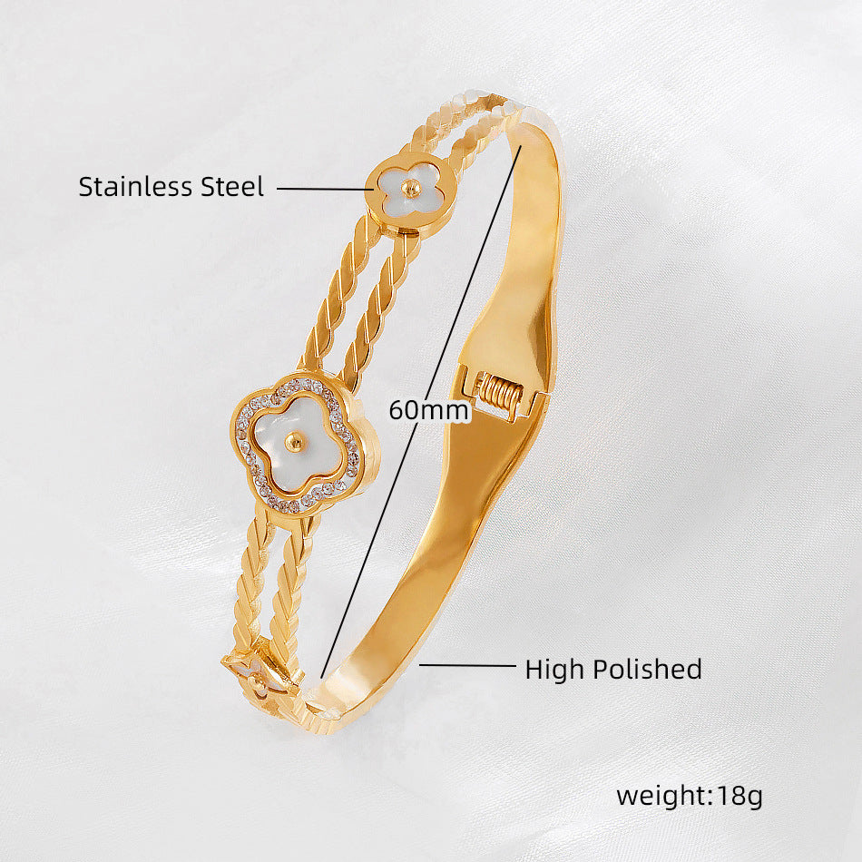 Vergoldeter Edelstahl-Armreif mit gedrehter Struktur und Perlmuttblüten