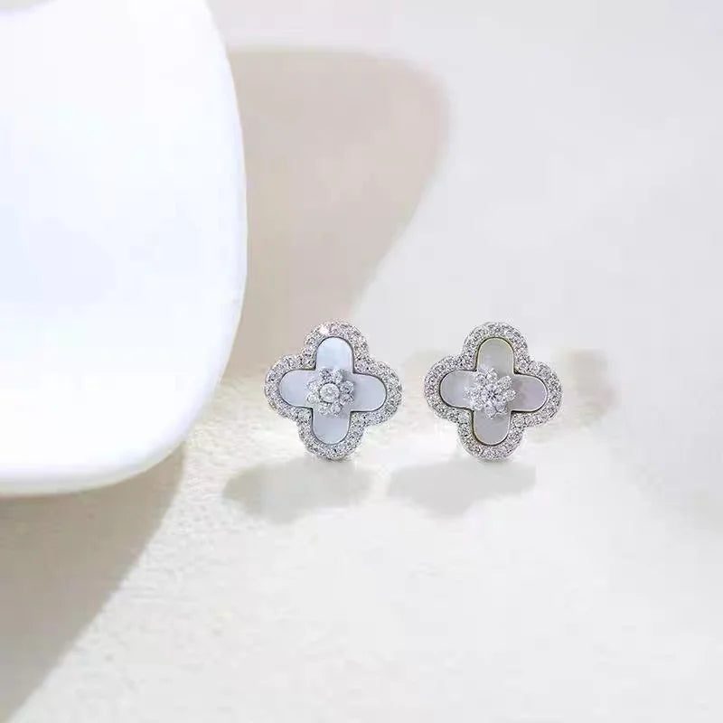 Silberne Ohrstecker in Blütenform mit weißer Einlage und Zirkonia