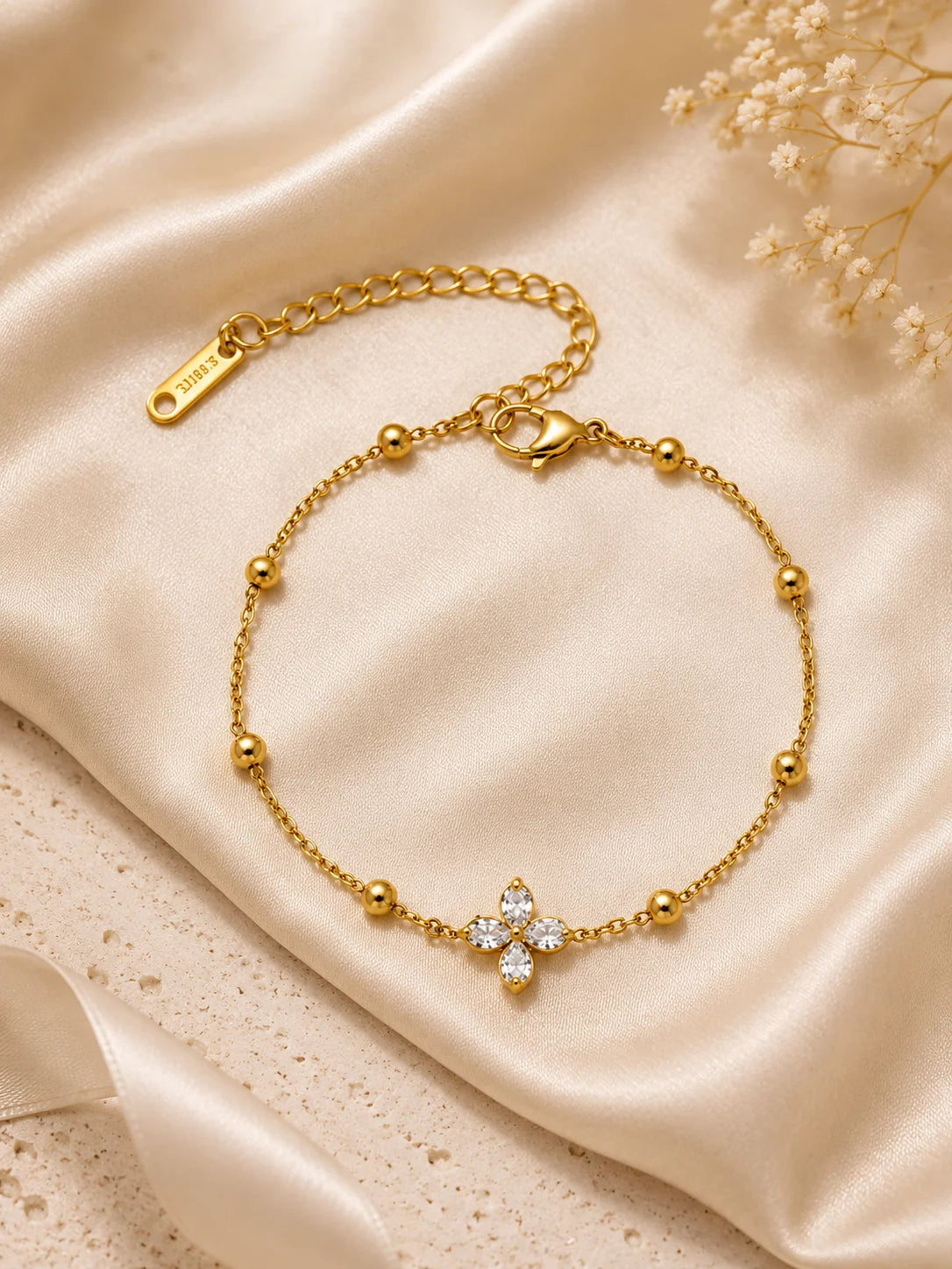 artes Blüten-Glanz Armband aus vergoldetem Titanstahl mit Zirkonia-Blüte und Goldperlen auf goldenem Satin