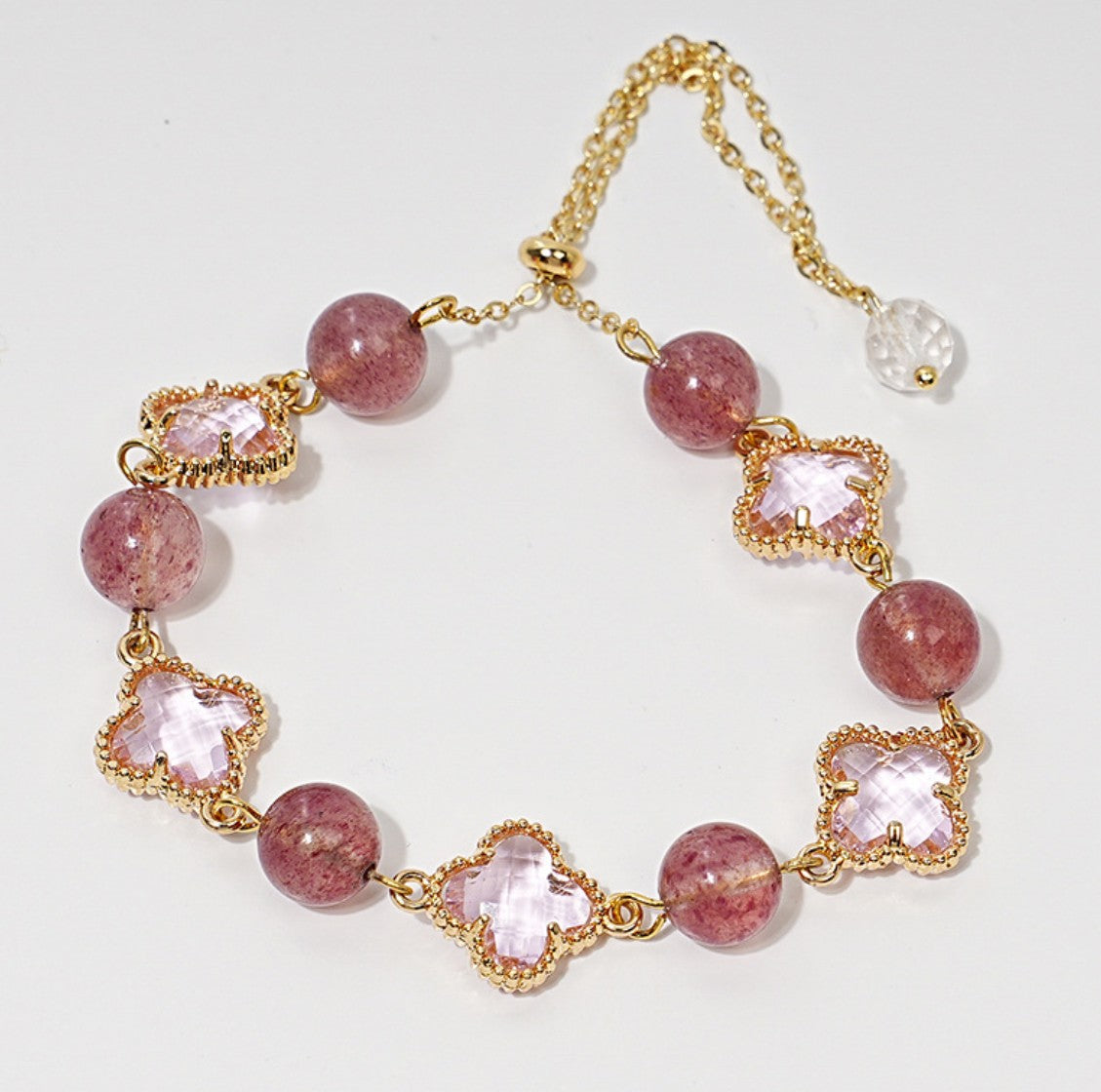 Zartes Armband mit rosa Erdbeerquarz-Perlen und funkelnden Zirkonia-Kleeblättern – romantisches Design mit Goldakzenten