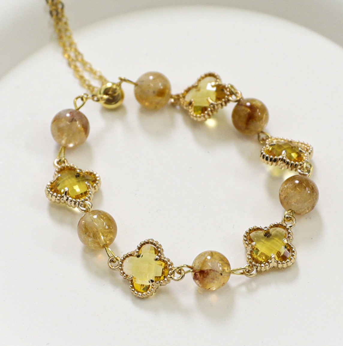 Elegantes Armband mit facettierten gelben Turmalinkristallen und 8 mm Zirkonia in Kleeblattform – sonniger Glanz in vergoldeter Fassung