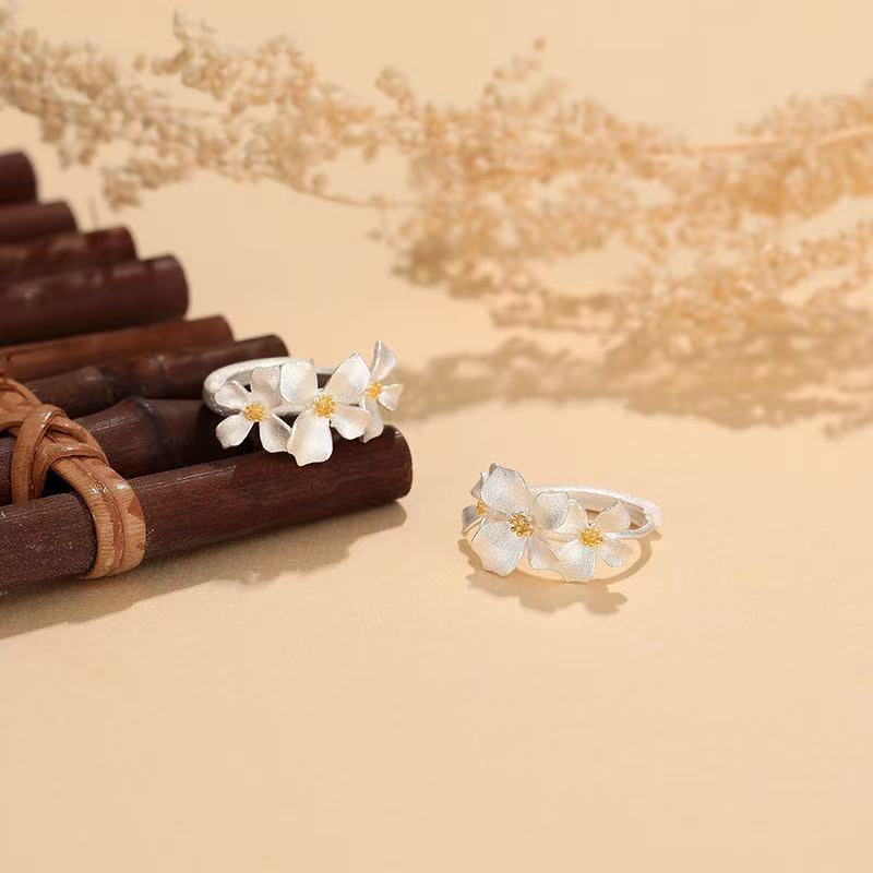Handgefertigte S999 Feinsilber-Creolen mit zarten Blüten und vergoldetem Zentrum – filigraner floraler Ohrschmuck in eleganter Ausführung