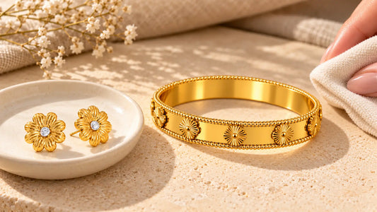 Goldener Blumenarmreif und Blumen-Ohrstecker werden mit einem weichen Tuch gepflegt