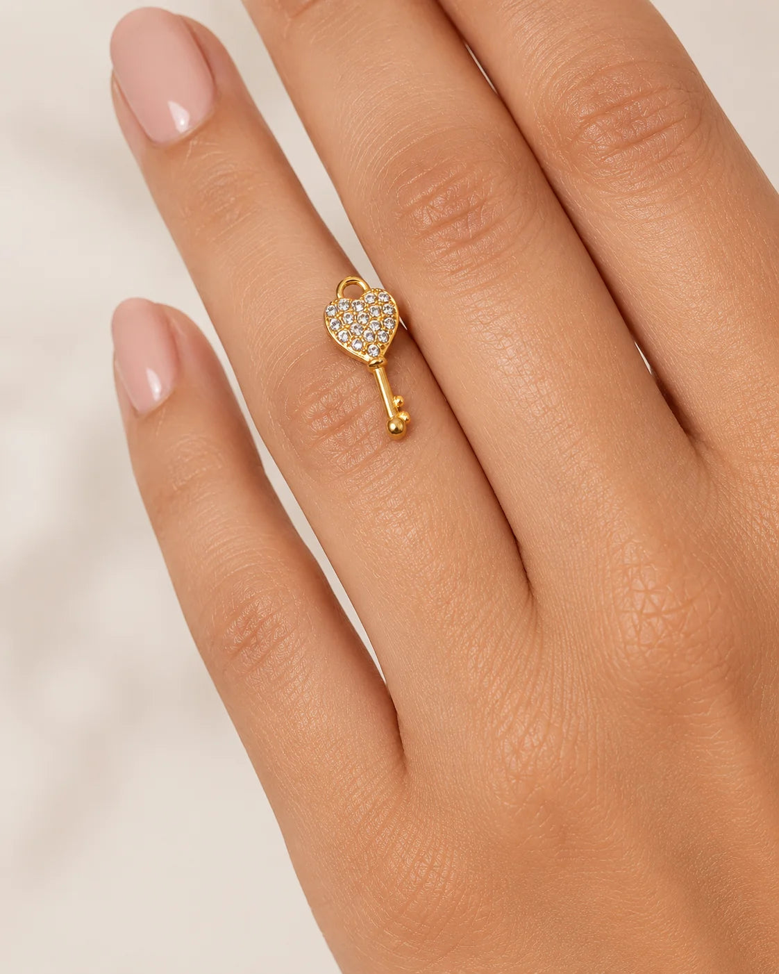 Zierlicher, goldener Anhänger aus 18K vergoldetem Titanstahl in Form eines Schlüssels mit einem herzförmigen, mit Zirkonia-Kristallen besetzten Kopf für personalisierbare Armbänder und Ketten