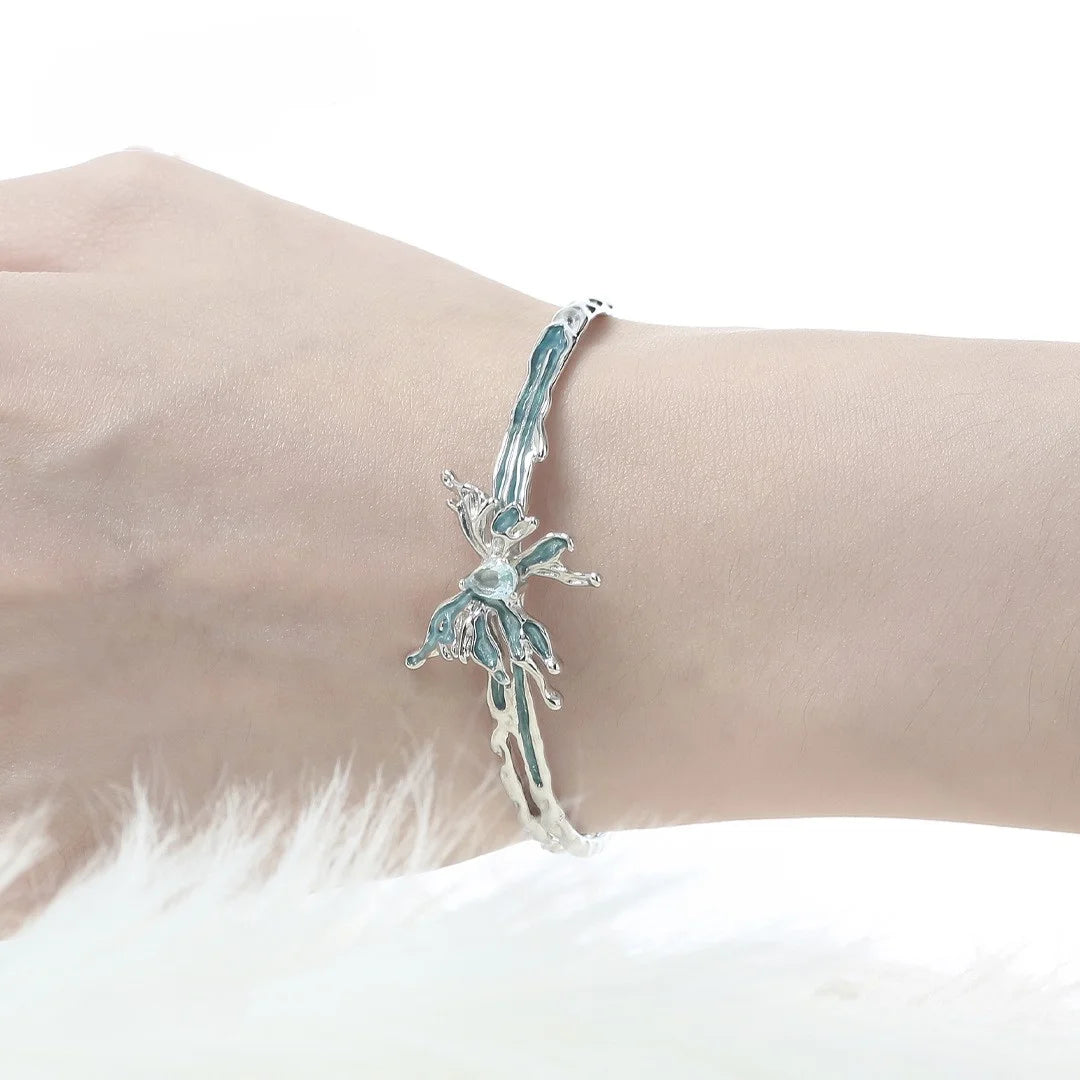Silberner Armreif in flüssiger Optik mit blauem Emaille Schmetterling und Kristall