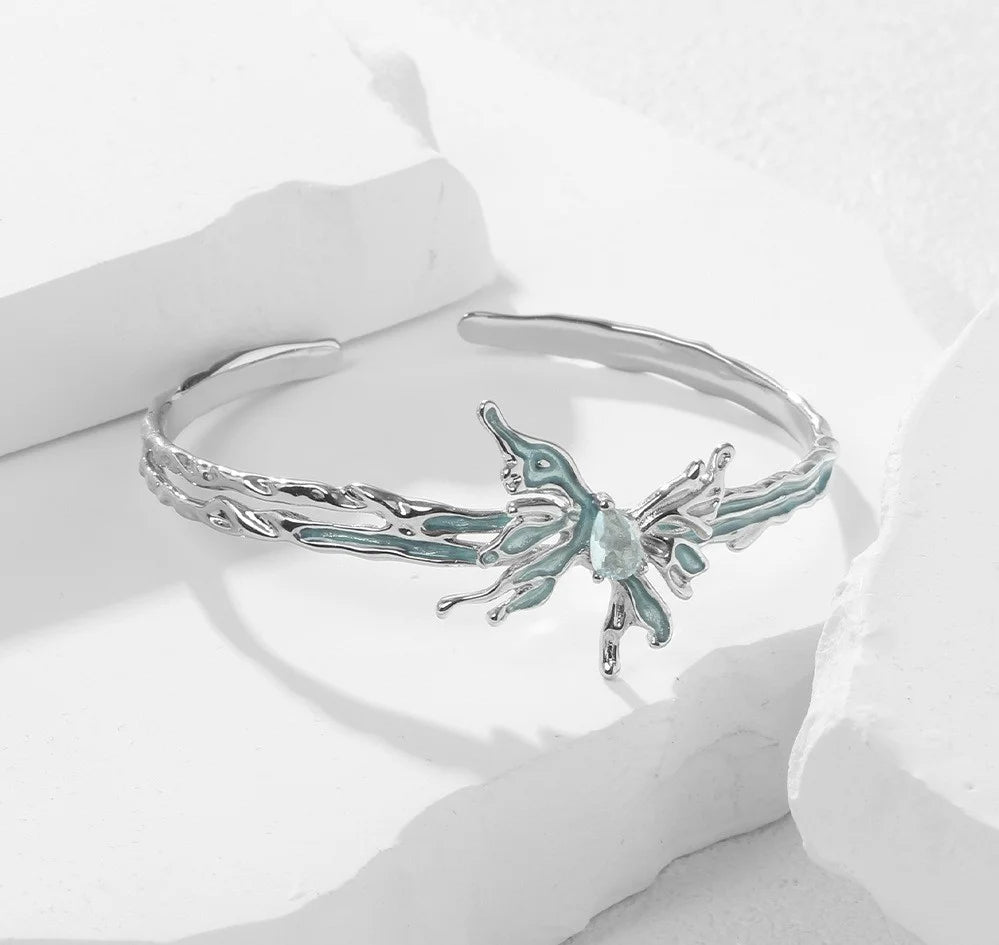 Silberner Armreif in flüssiger Optik mit blauem Emaille Schmetterling und Kristall