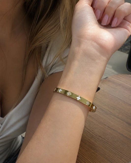 Goldener Blüten Armreif aus Edelstahl mit weißen Perlmutt Details
