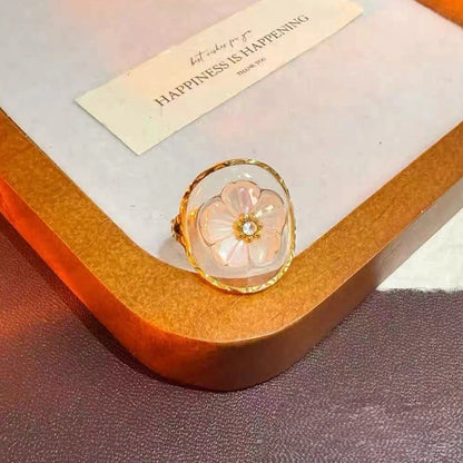 Vergoldeter Edelstahlring mit Blume aus Muschel in klarem Harz – romantisch, verstellbar, Statement-Look
