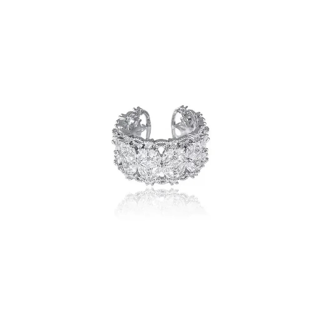 Breiter silberner Ring mit funkelnden Zirkonia Steinen in Blütenform auf schwarzem Hintergrund