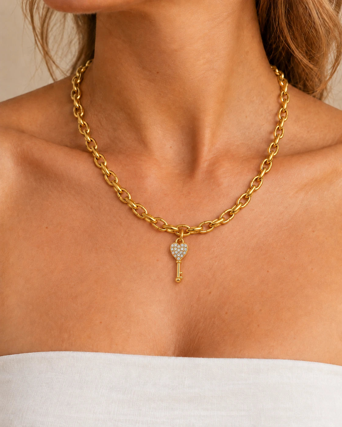 Goldene Clara Charm-Kette aus Edelstahl mit Schlüsselanhänger, am Hals einer Frau getragen – Stylingbeispiel