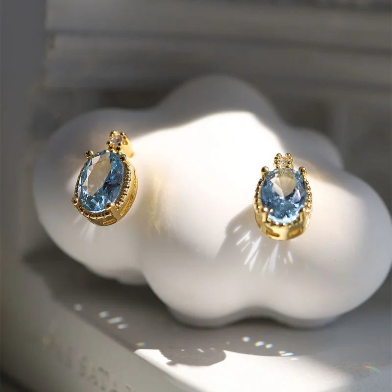 Goldene Ohrstecker mit ovalem blauem Aquamarin und kleinen Diamanten