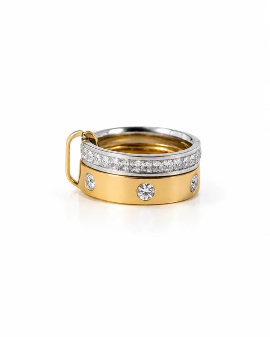 Geschlossener Bicolor-Doppelring aus Titanstahl, bestehend aus zwei ineinander verschlungenen Ringen – einer silberfarben mit durchgehenden Steinen, einer goldfarben mit einzeln gefassten Kristallen.