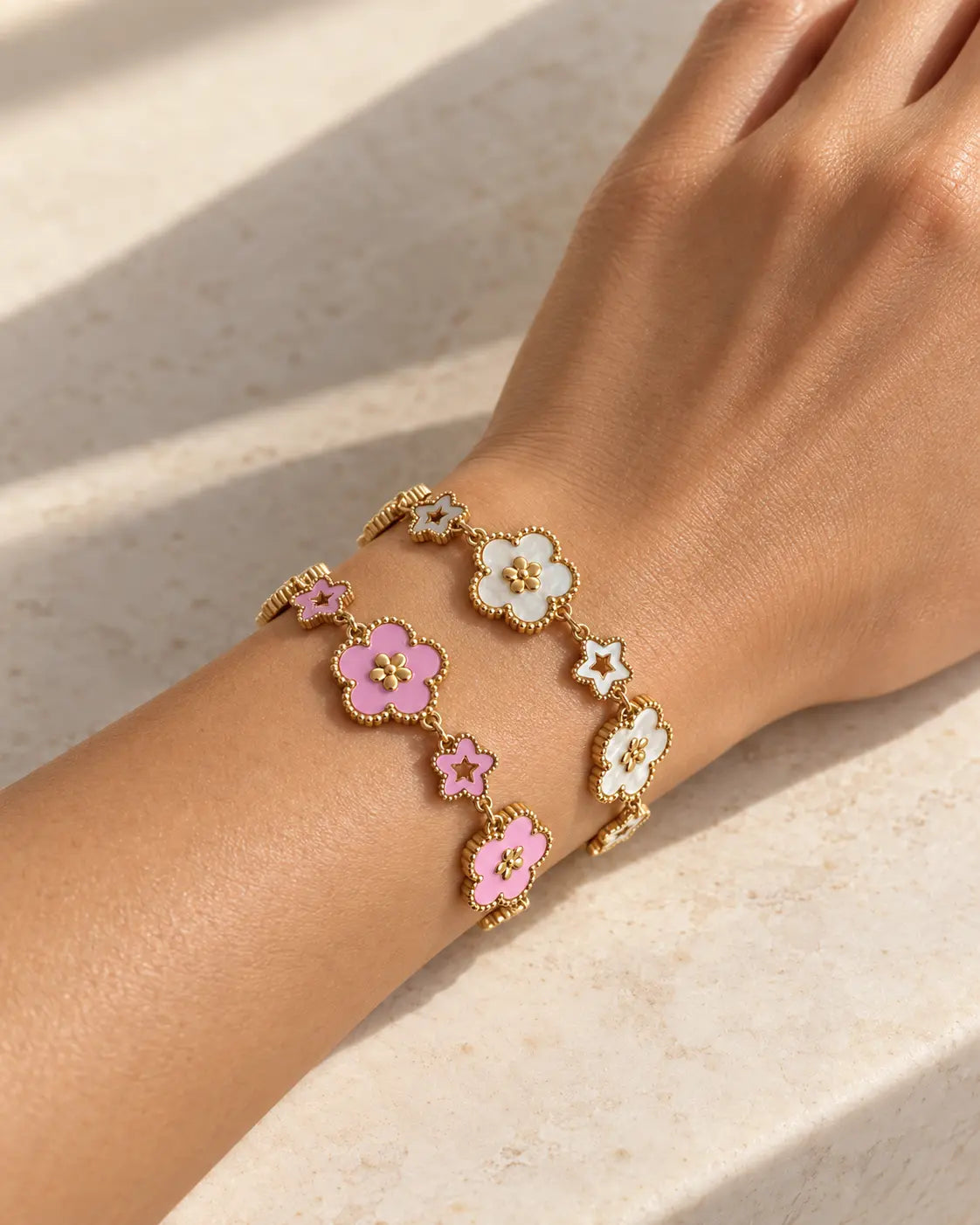 Elise Blumen Armband in Gold mit weißen und rosa Emaille-Blüten am Handgelenk