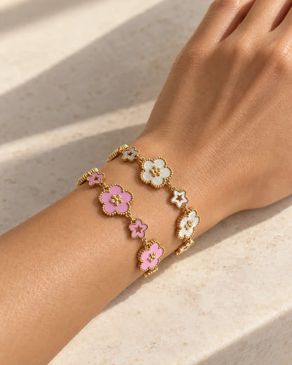 Elise Blumen Armband in Gold mit weißen und rosa Emaille-Blüten am Handgelenk