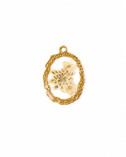 Ovaler, goldener Anhänger aus 18K vergoldetem Titanstahl mit einem gehämmerten Rahmen und einem klaren Acryl-Zentrum, in das echte, weiße Trockenblumen eingebettet sind, ideal für personalisierbare Armbänder und Ketten