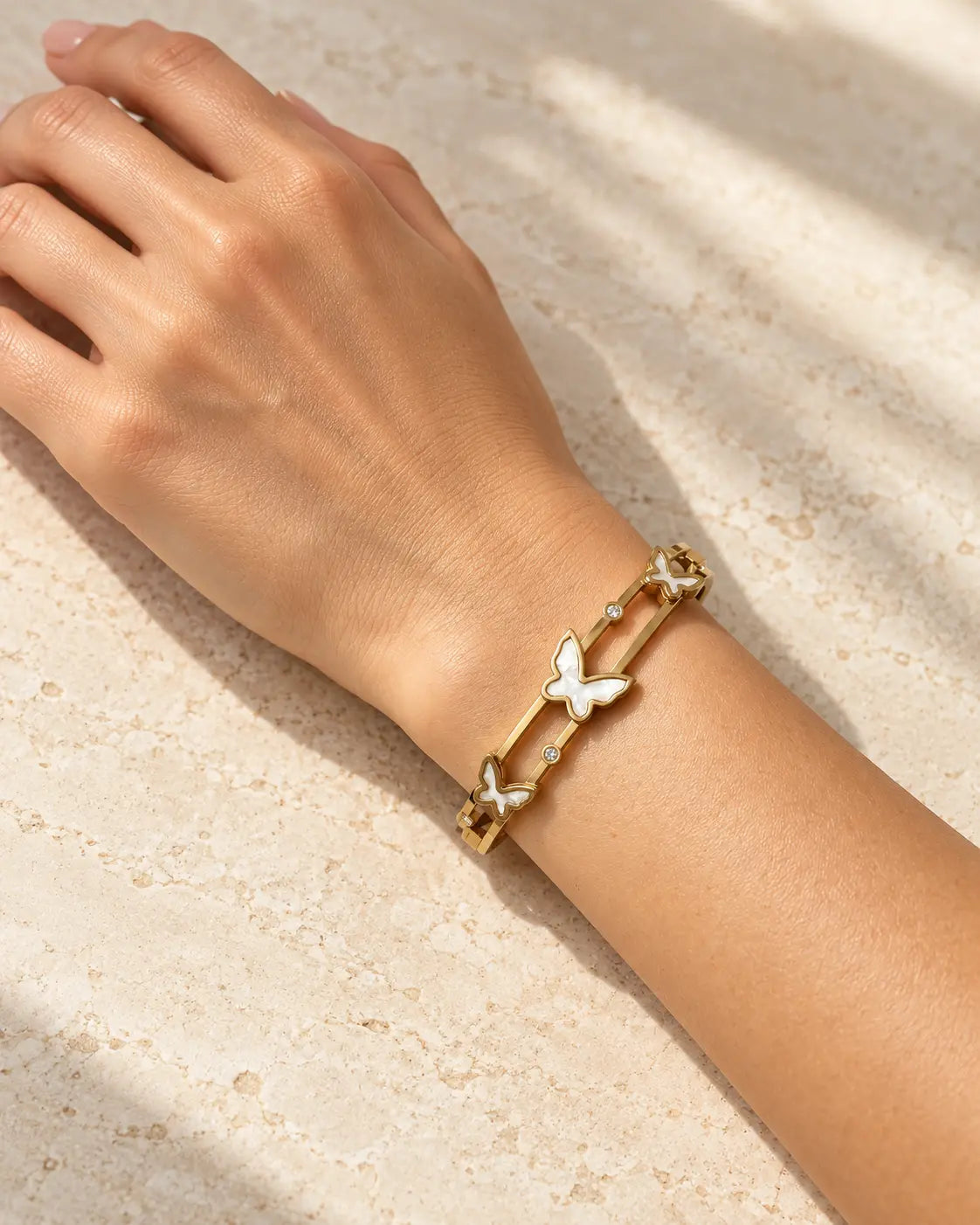 Perlmutt Schmetterlinge und Zirkonia am goldenen Doppelarmreif im Detail