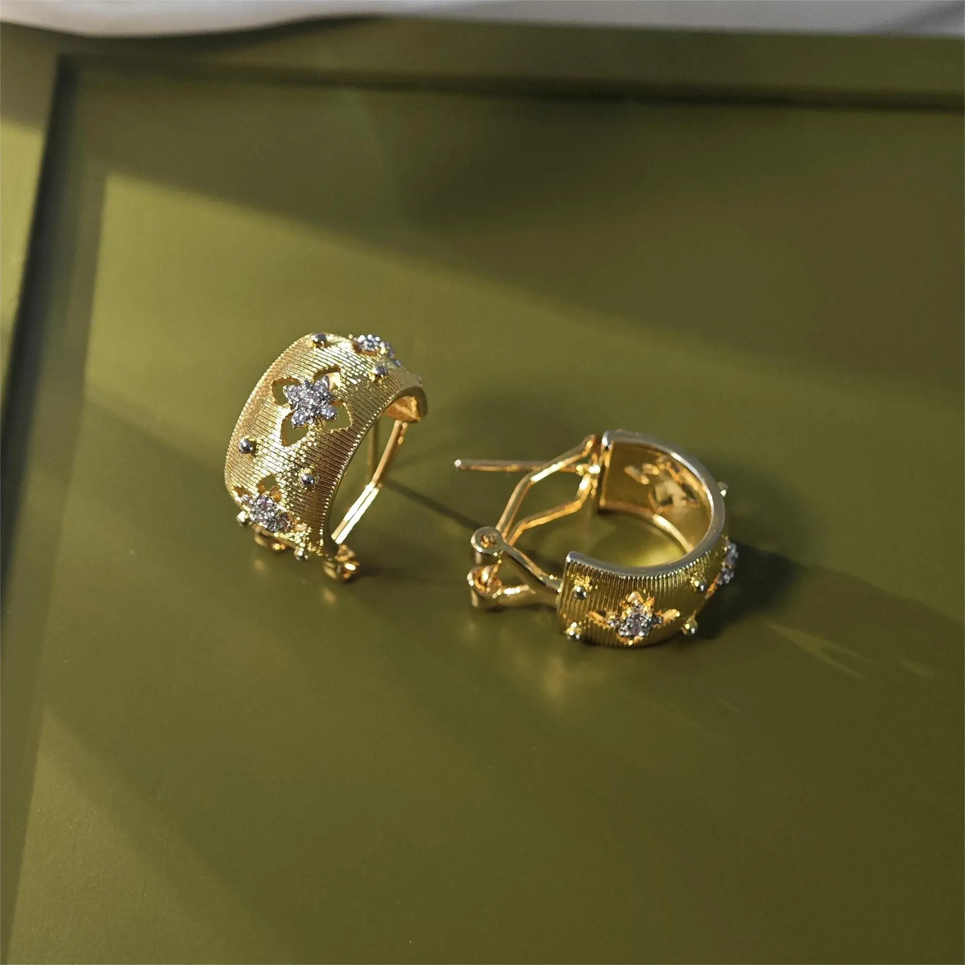 Vergoldete Ohrringe mit gebürsteter Textur und durchbrochenem vierblättrigem Kleeblatt-Muster