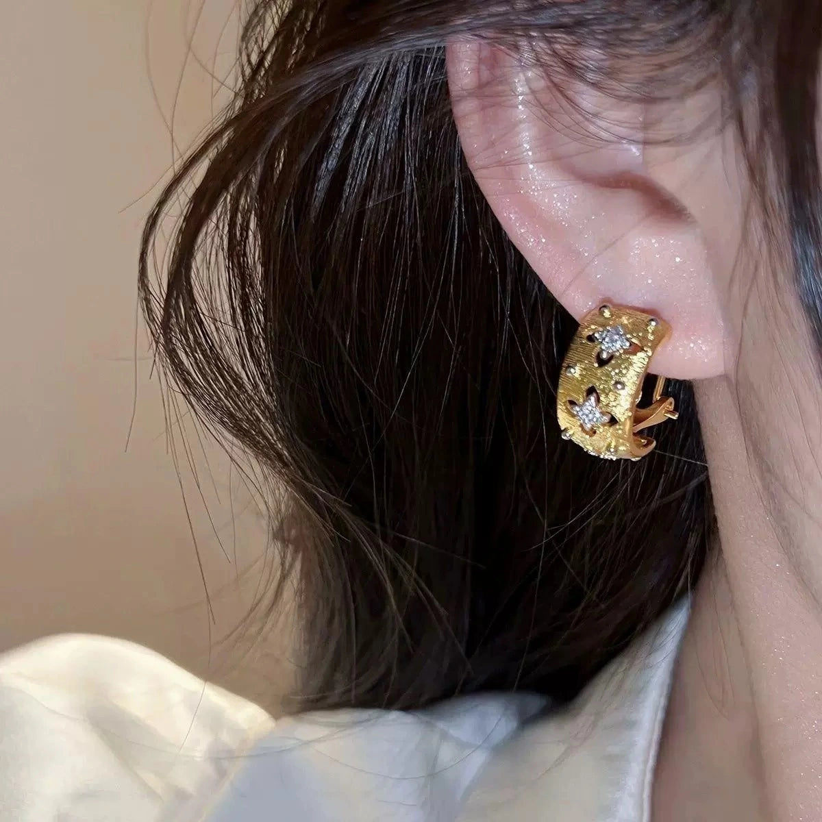 Vergoldete Ohrringe mit gebürsteter Textur und durchbrochenem vierblättrigem Kleeblatt-Muster