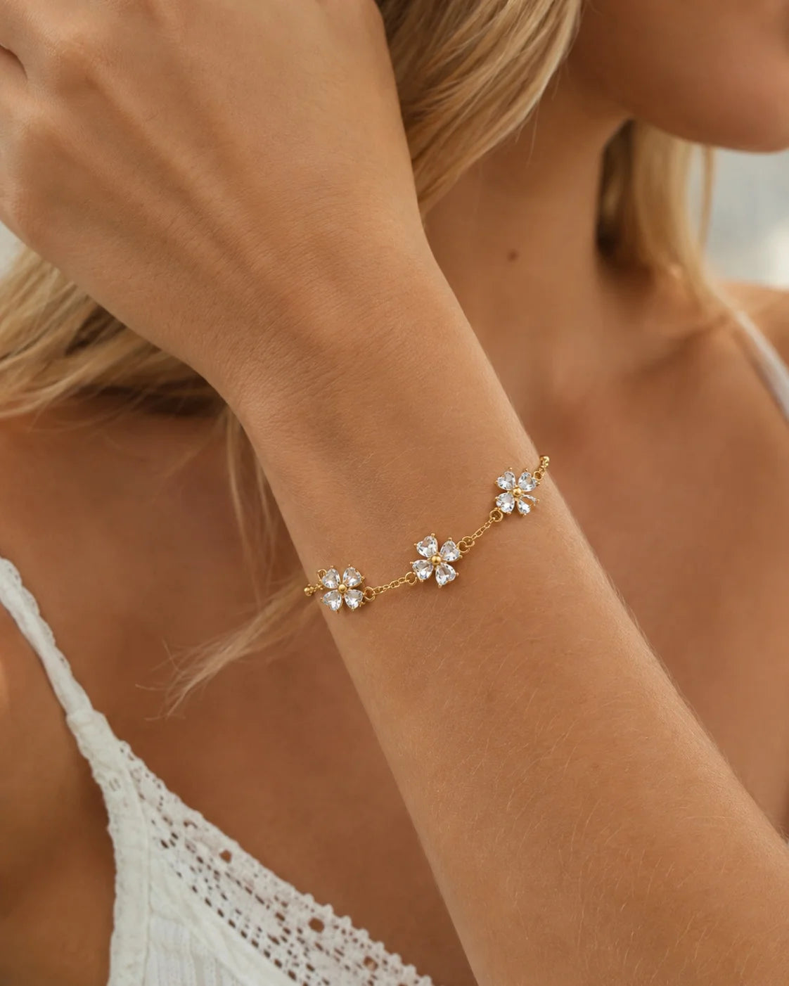 Frau trägt florales Zirkonia Armband aus vergoldetem Titanstahl