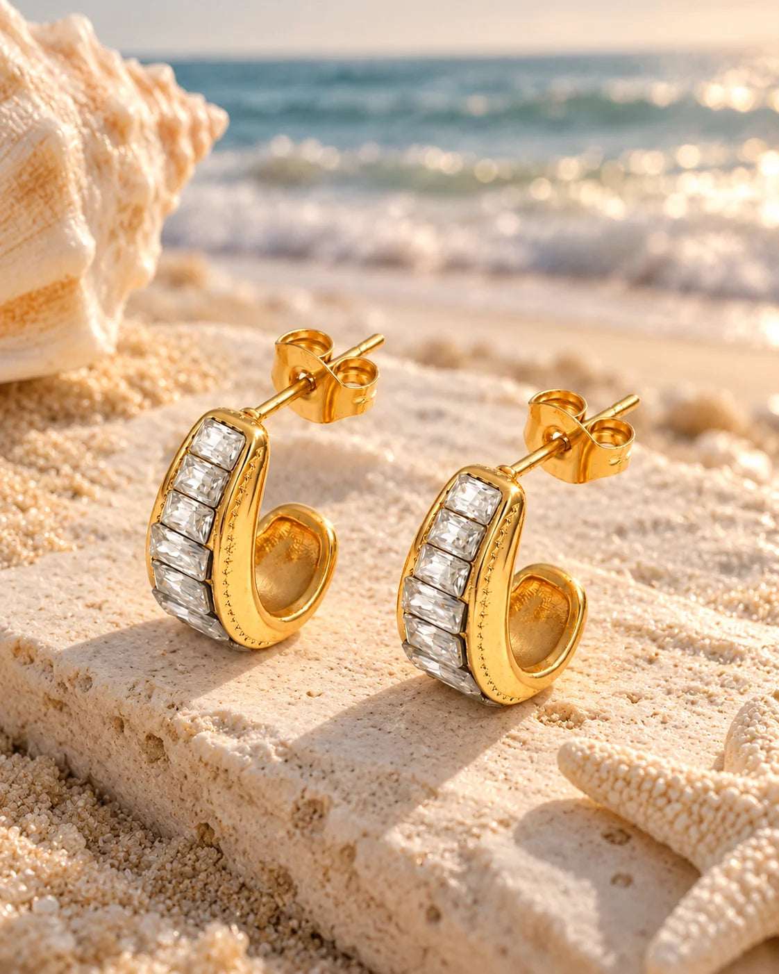Goldene Zirkonia Creolen aus Edelstahl in sommerlicher Strandkulisse