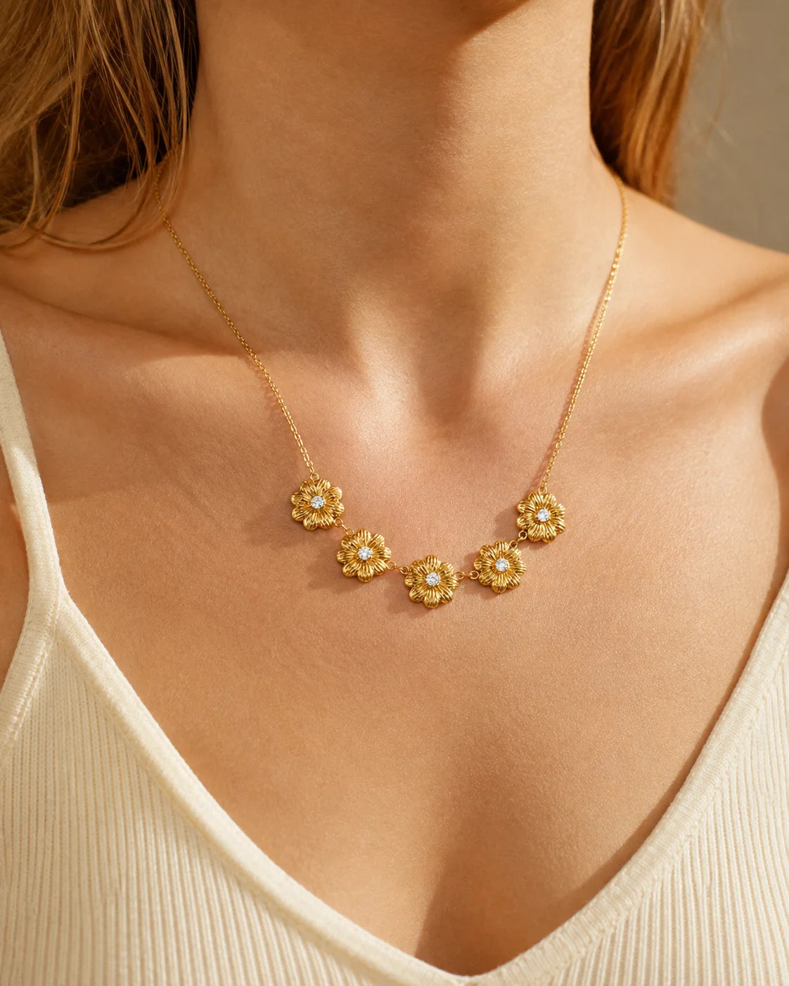 Florale goldene Halskette mit fünf Blütenmotiven getragen