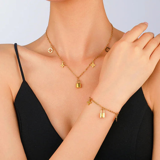 Goldenes Schmuckset aus Titanstahl bestehend aus Halskette und Armband mit Kleeblatt- und Schloss-Anhängern