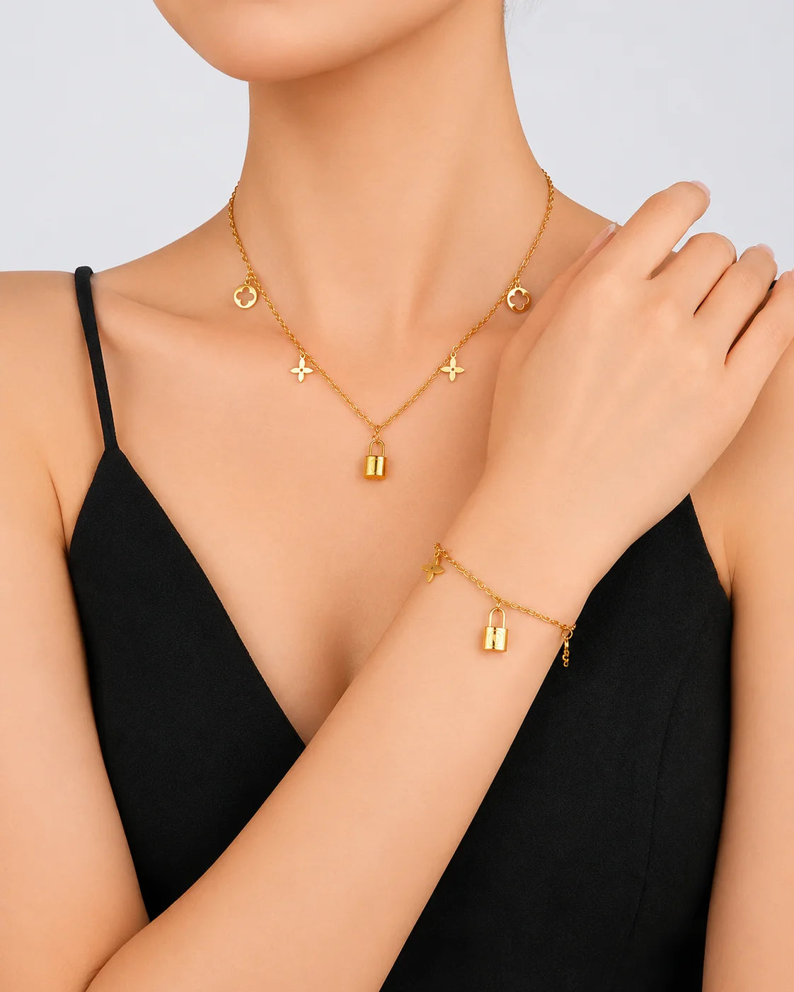 Goldenes Schmuckset aus Titanstahl bestehend aus Halskette und Armband mit Kleeblatt- und Schloss-Anhängern