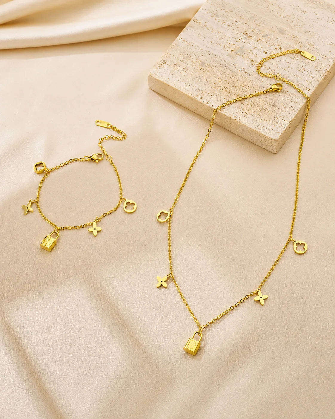 Goldenes Schmuckset aus Titanstahl bestehend aus Halskette und Armband mit Kleeblatt- und Schloss-Anhängern