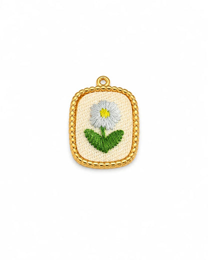 Ovaler, goldener Anhänger aus 18K vergoldetem Titanstahl mit Kugelbordüre und einem textilen Inlay, auf dem eine weiße Margerite gestickt ist, für personalisierbare Armbänder und Ketten