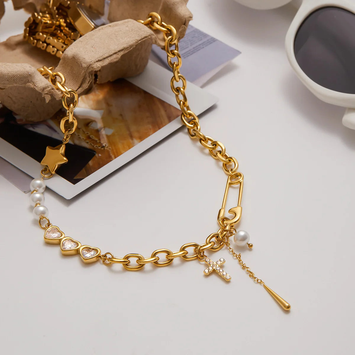 Goldene Statement-Halskette "Harper" aus Edelstahl mit Sicherheitsnadel, Kreuz, Perlen, Stern und Zirkonia-Herzen