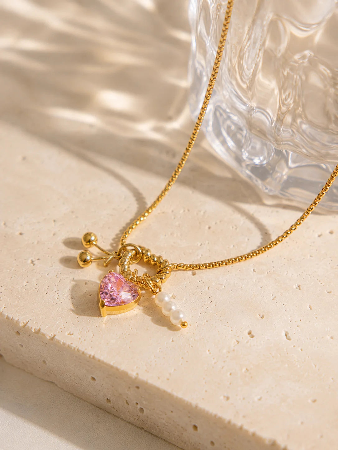 Charm-Halskette aus 18K vergoldetem Titanstahl mit gedrehtem Herz-Ring, rosa Kristallherz, goldenen Kirschen und Perlen-Anhängern