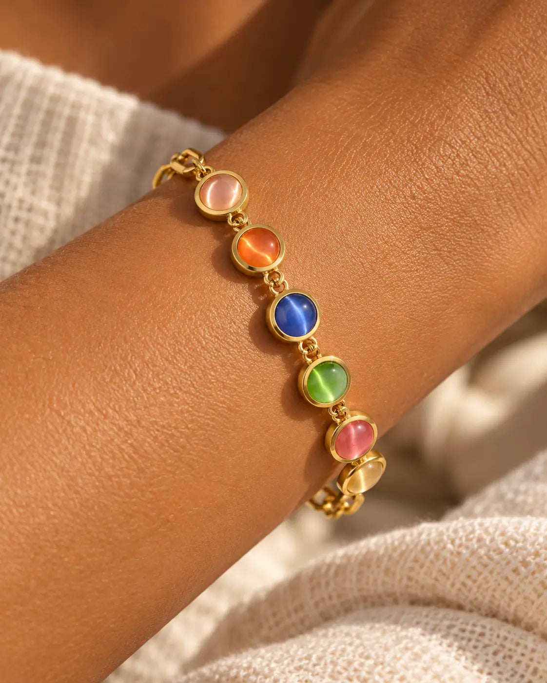 Buntes Katzenauge Armband in Gold am Handgelenk getragen