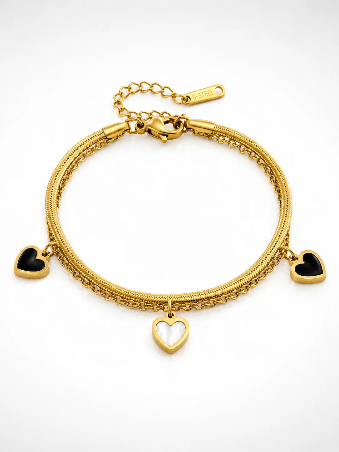 Zweilagiges Clara's Kontrast-Herzen Armband aus 18K vergoldetem Titanstahl mit drei schwarz-weißen Herzanhängern auf Marmorgrund